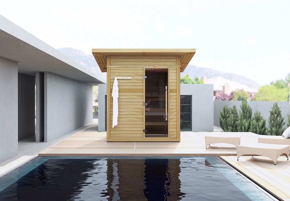 Modern patio with a small wooden sauna beside a pool and lounge chairs, set against a bright hillside view