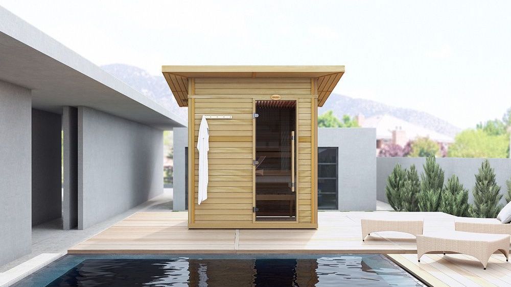 Modern poolside patio with a small wooden sauna cabin and lounge chairs in a bright courtyard