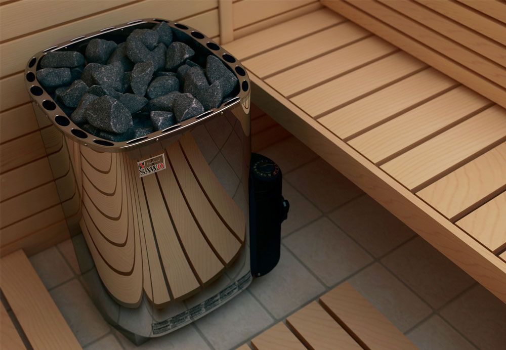 Sauna heater filled with stones beside a wooden bench on tiled floor