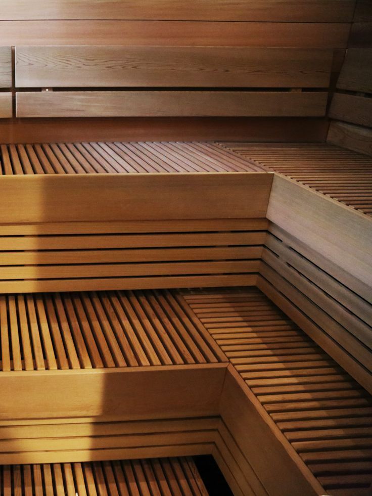 Wood-paneled sauna benches with warm brown slatted seating and walls