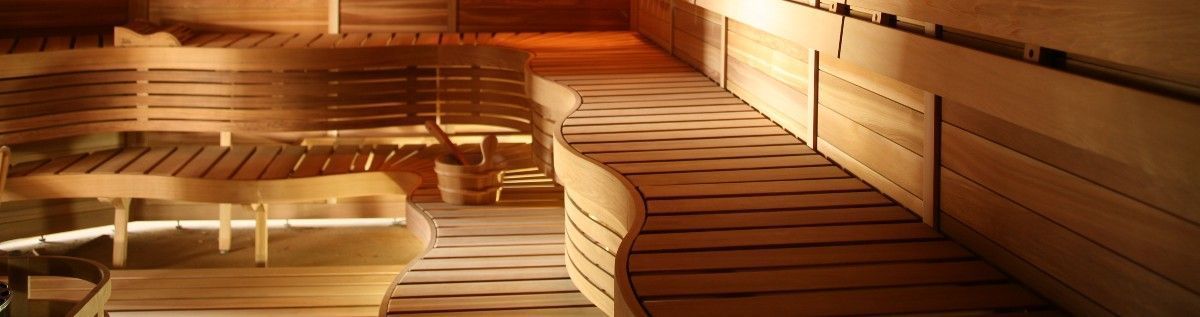 Warm wooden sauna interior with curved benches and soft amber lighting
