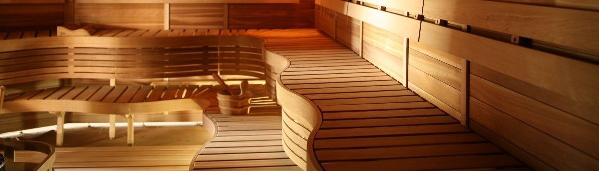Warm wooden sauna with tiered benches and soft orange lighting
