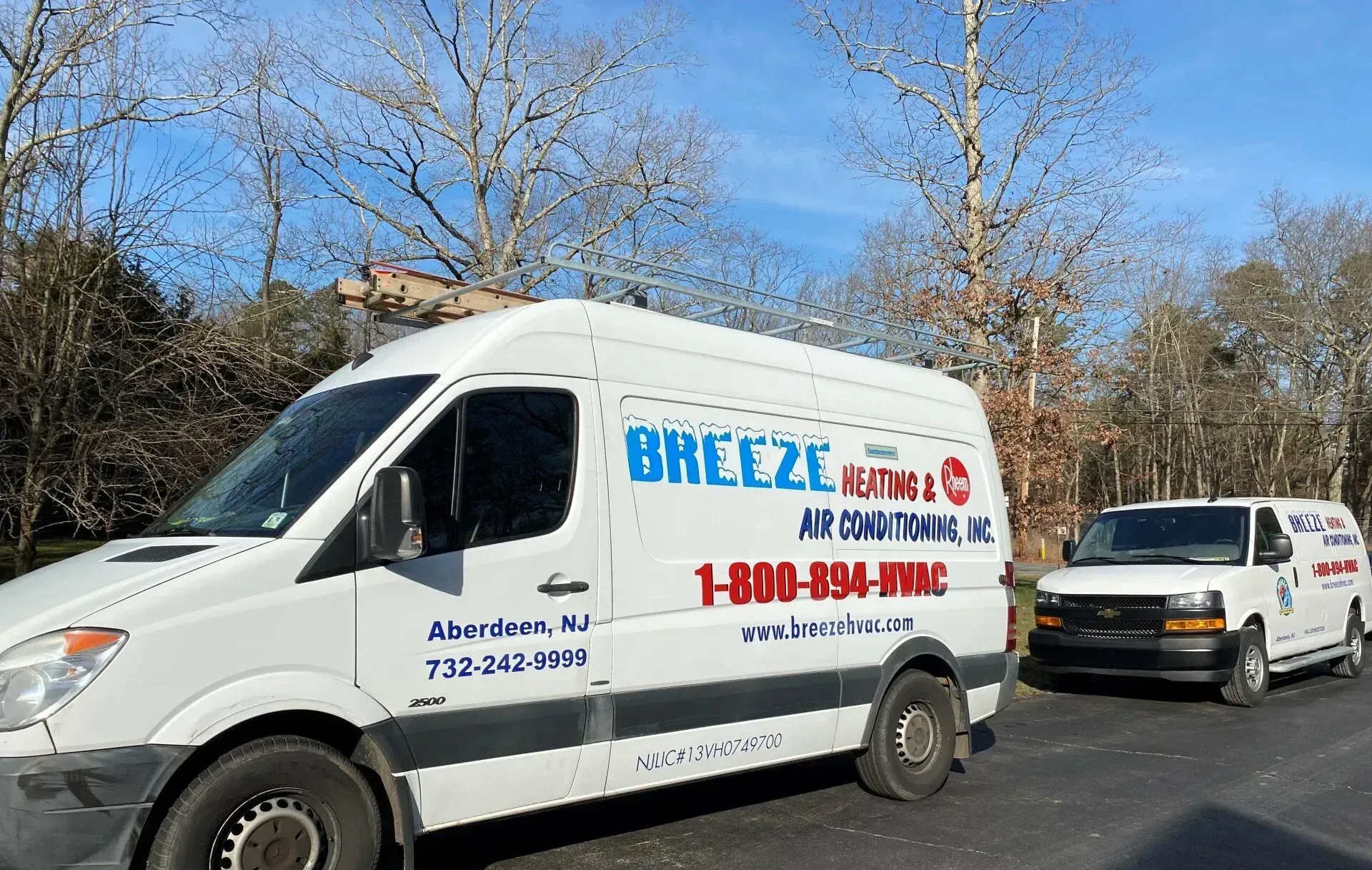 White Breeze Moving van and a pickup truck parked on a roadside under blue sky