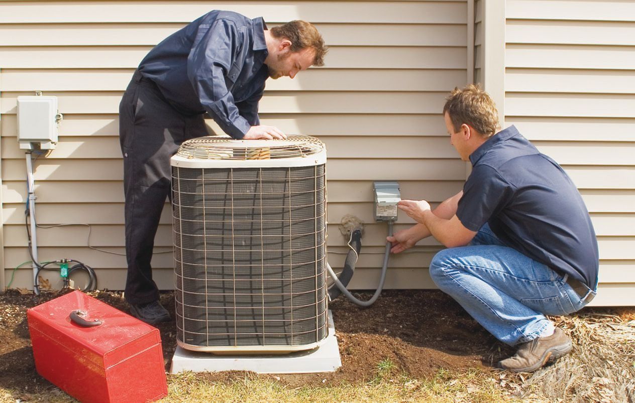 Two technicians inspecting an outdoor air conditioner unit beside a house