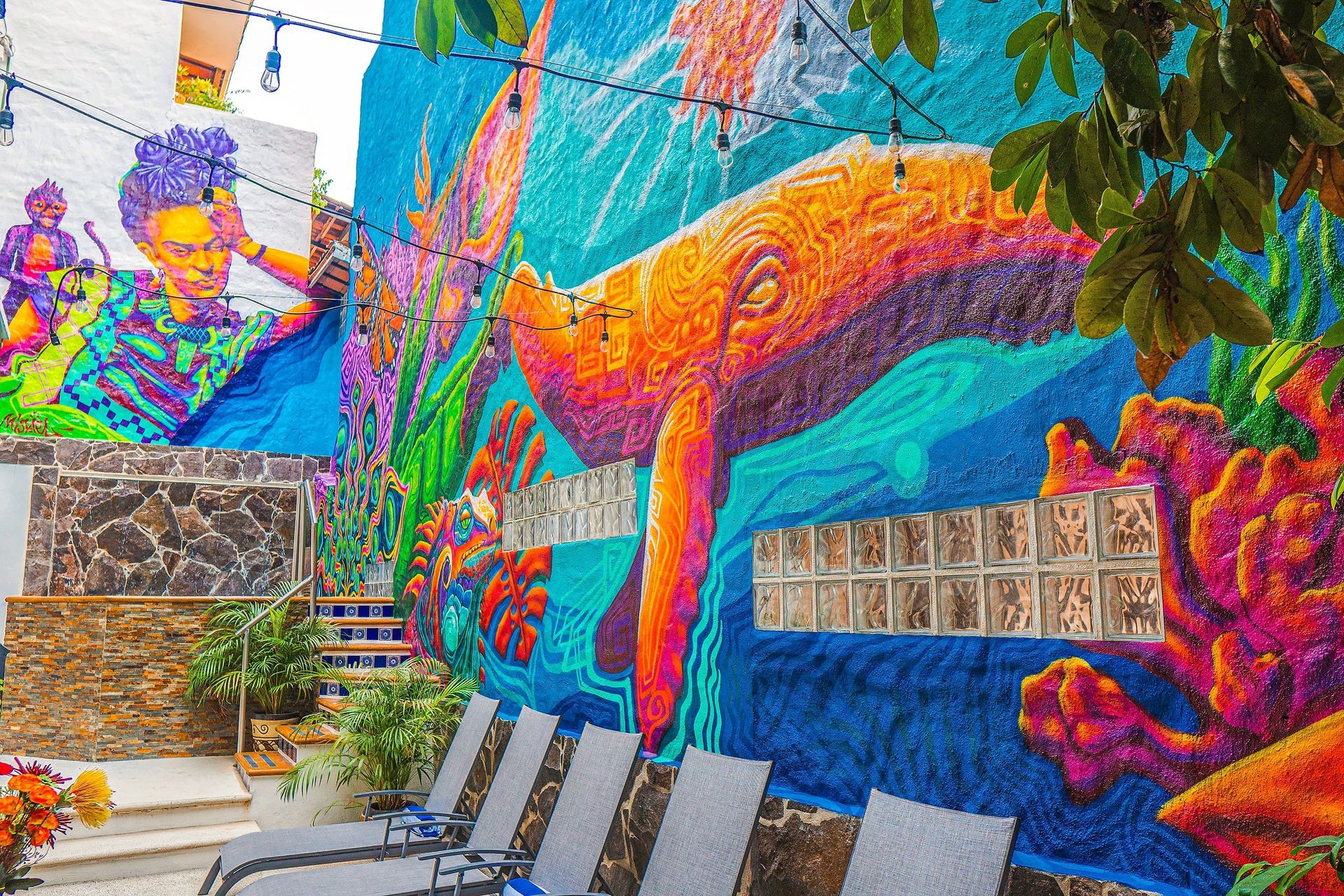 Colorful mural with a whale, person, and coral in outdoor setting.
