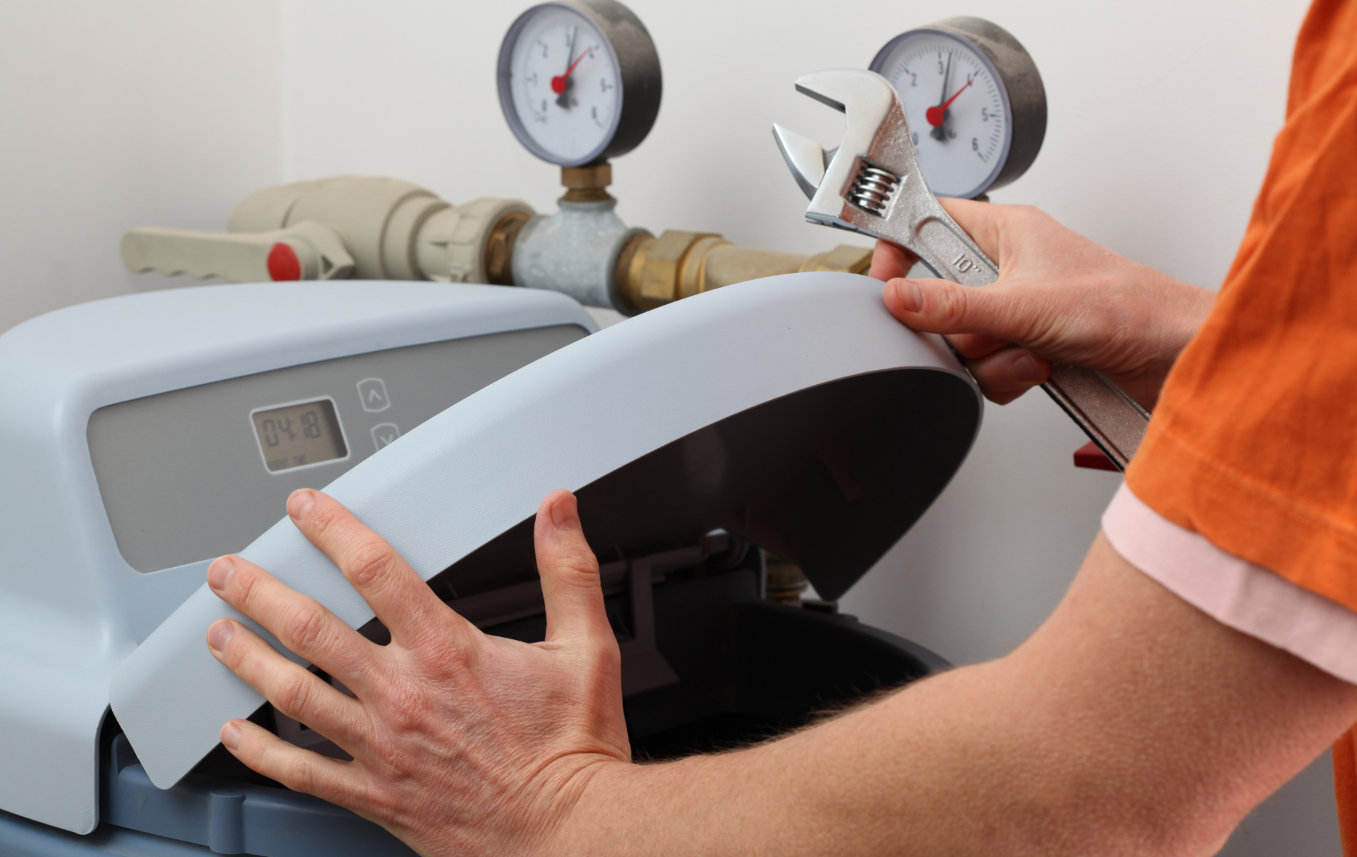Technician testing boiler pressure gauges and controls on a heating system