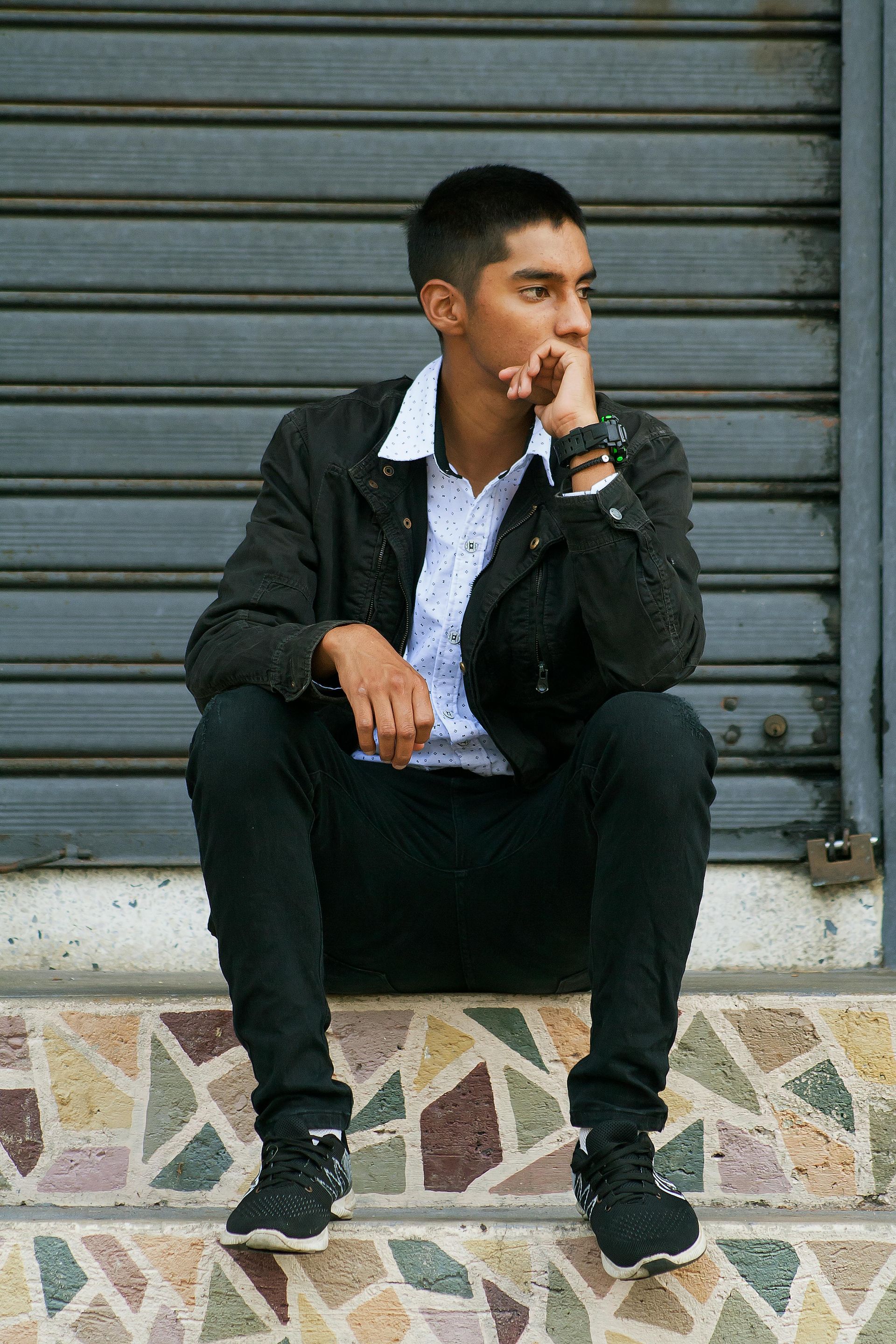 A woman in a yellow shirt is smelling a sunflower in a field.