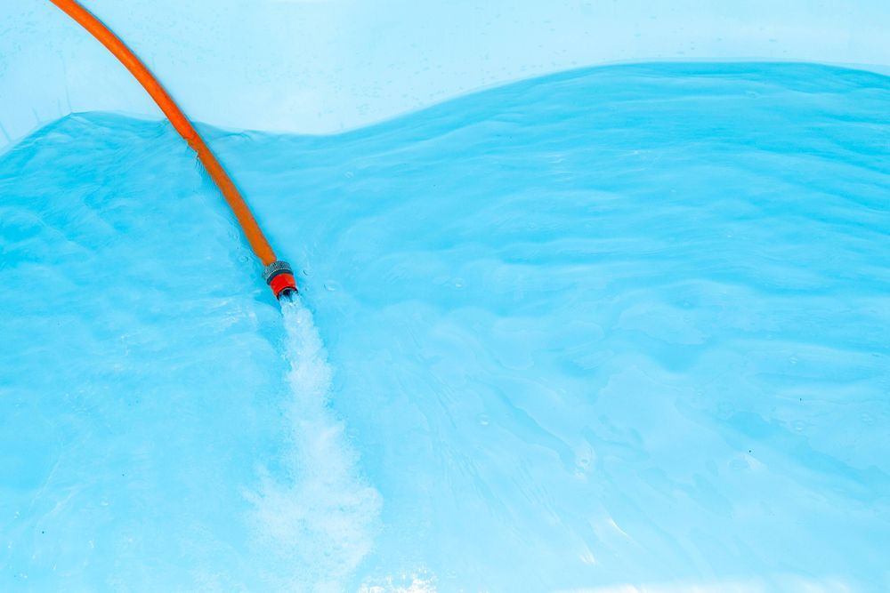 Orange Hose Spraying Water — Clearwater Pools Hallidays Point in Harrington, NSW