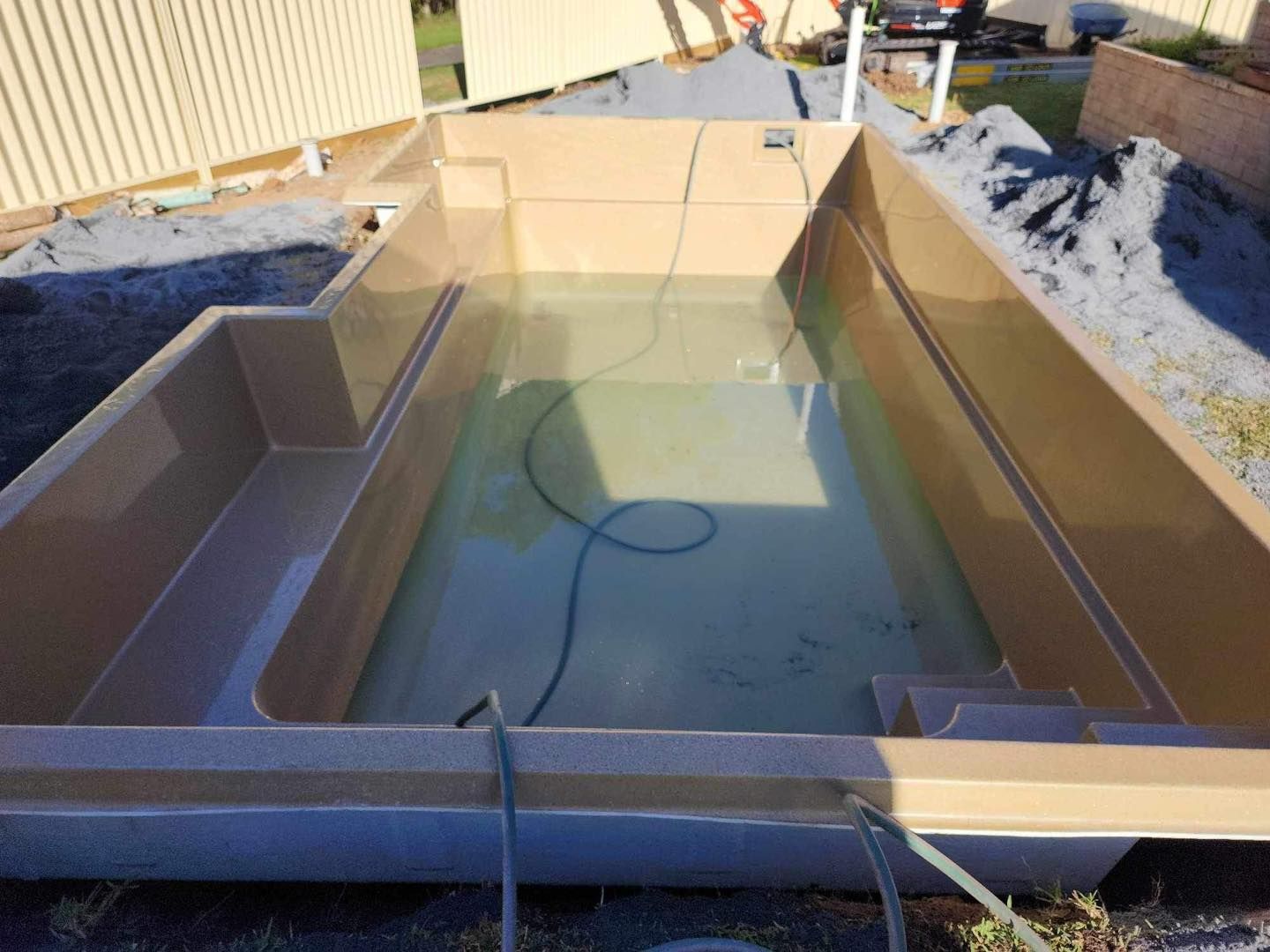 Newly Constructed Tan-coloured Swimming Pool With Water — Clearwater Pools Hallidays Point in Gloucester, NSW