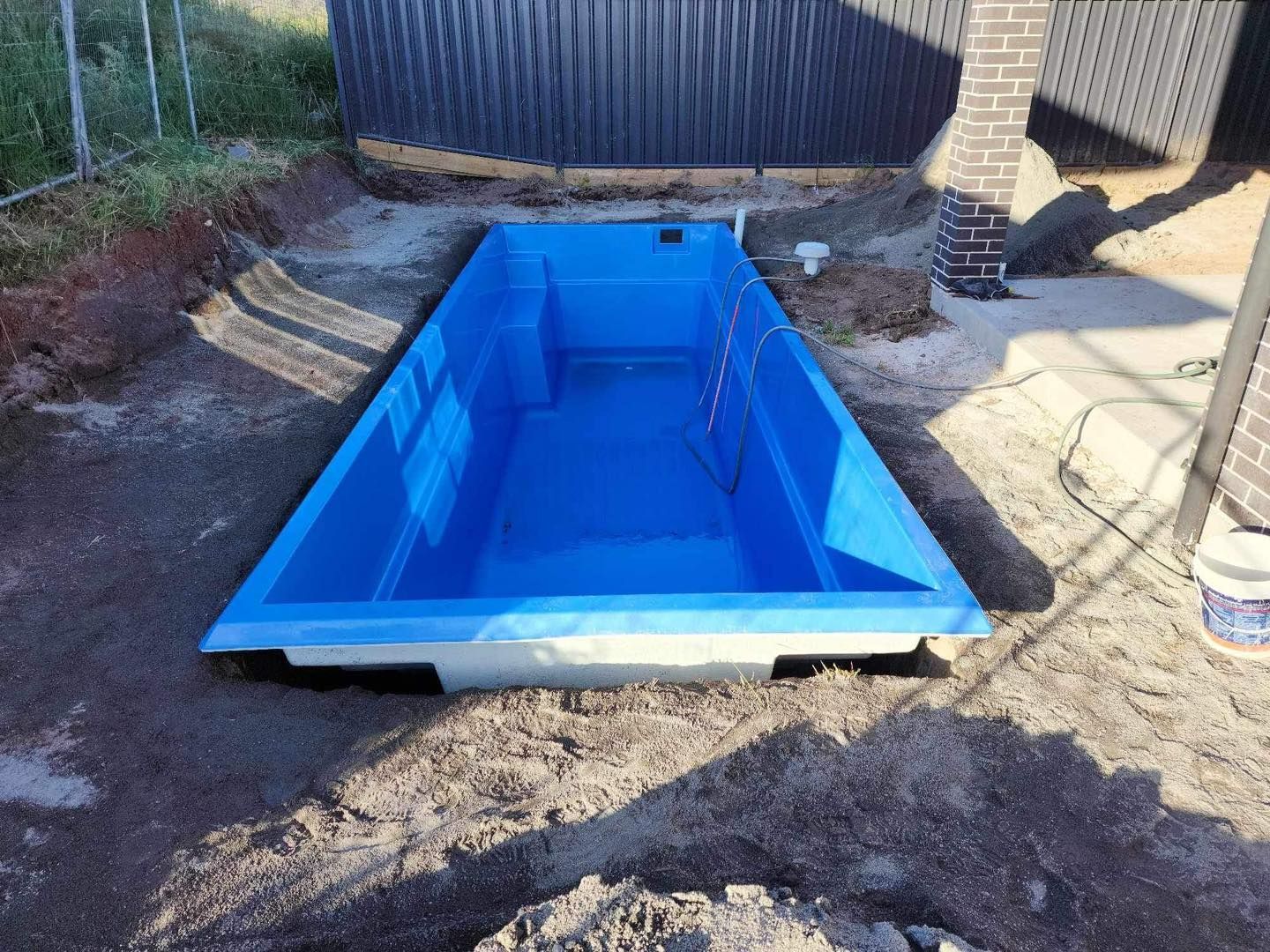 Blue Rectangular Pool Shell Installed in a Dirt Excavation, Near a Fence — Clearwater Pools Hallidays Point in Nabiac, NSW
