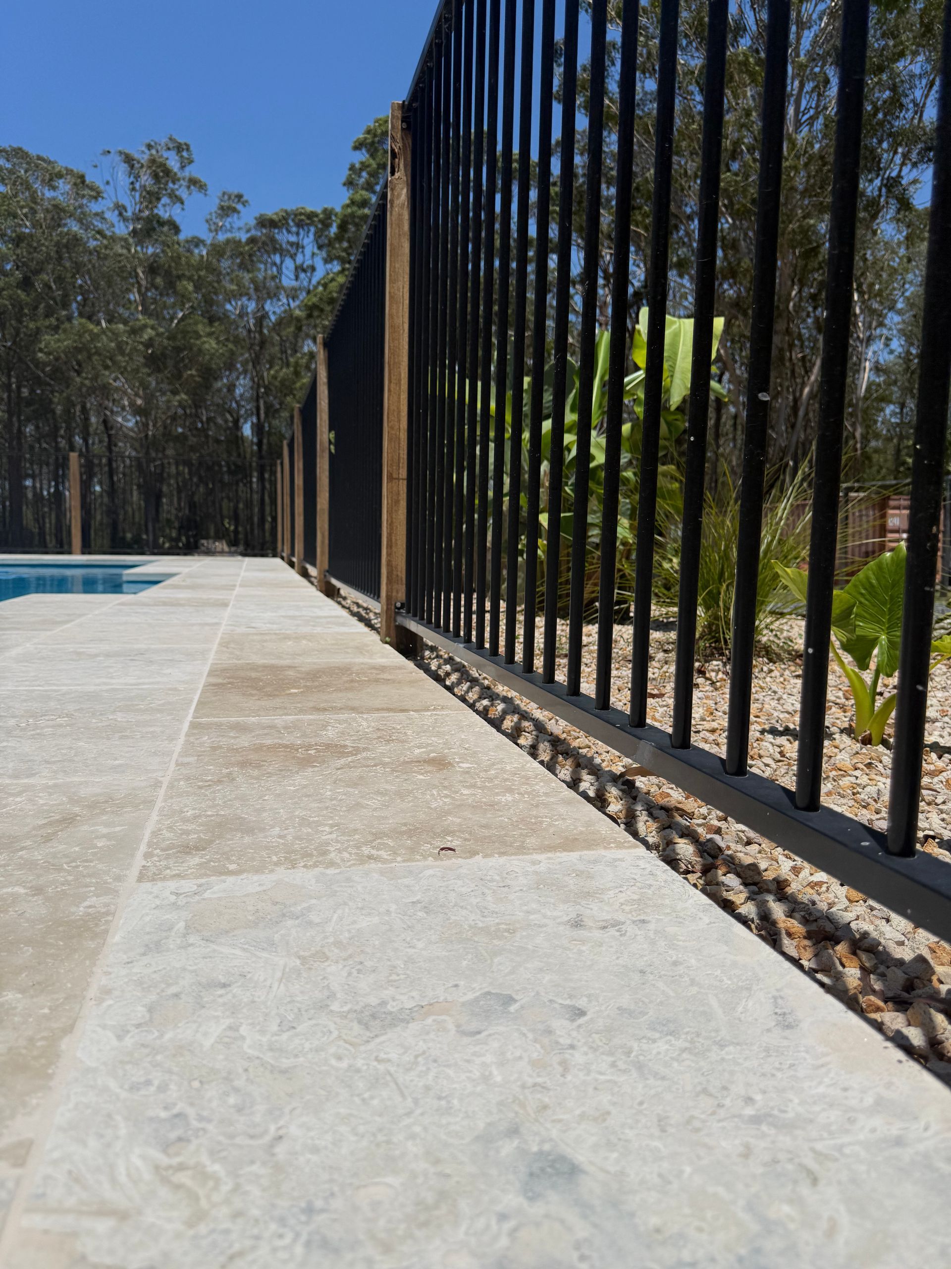 Swimming Pool With Black Metal Fence and Concrete Surround — Clearwater Pools Hallidays Point in Hallidays Point, NSW