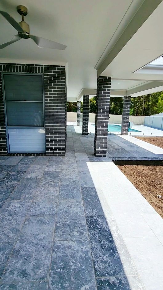 Covered Patio With Brick Pillars, Tiled Floor, and a Pool — Clearwater Pools Hallidays Point in Hallidays Point, NSW