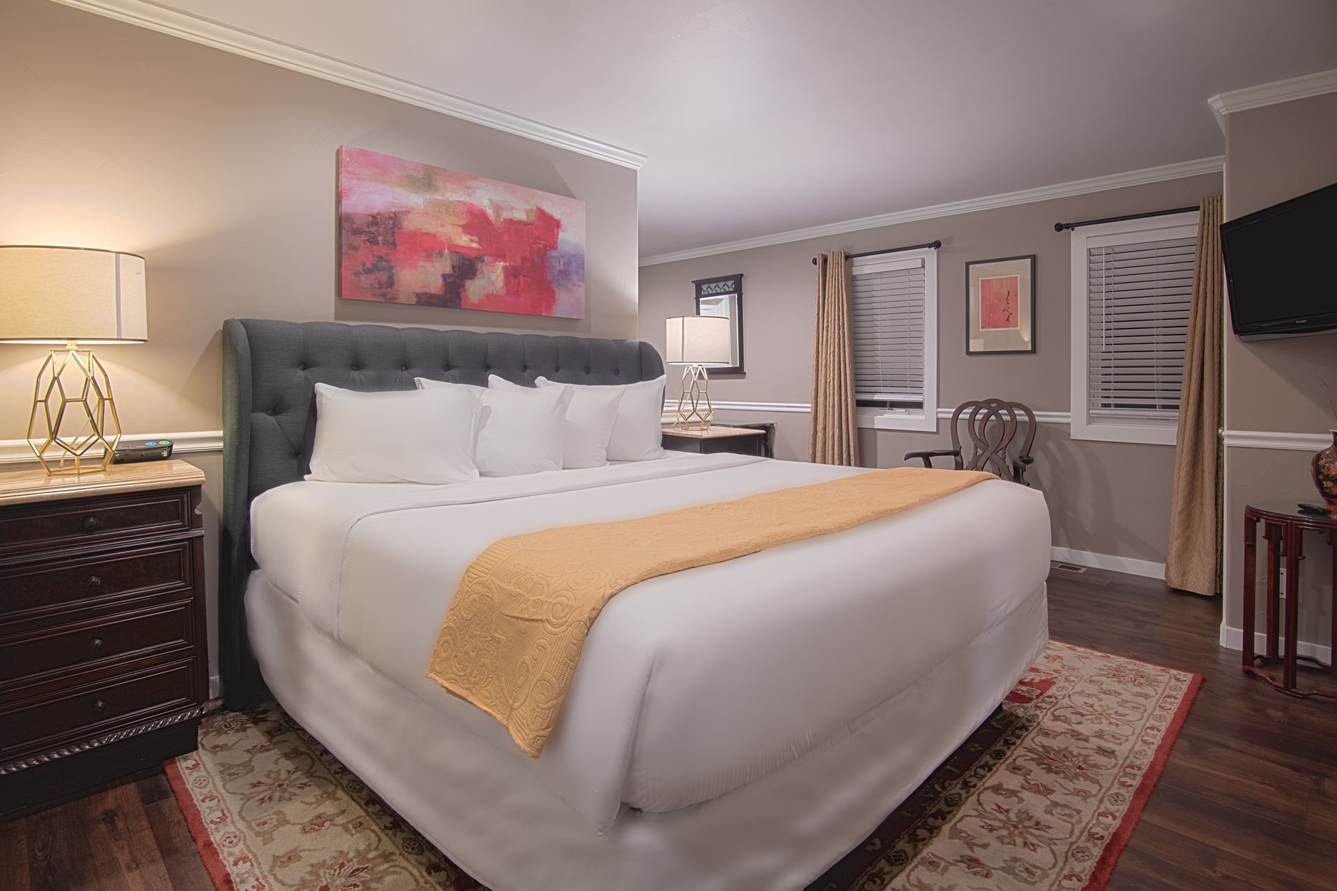 A hotel room with a king size bed and a television