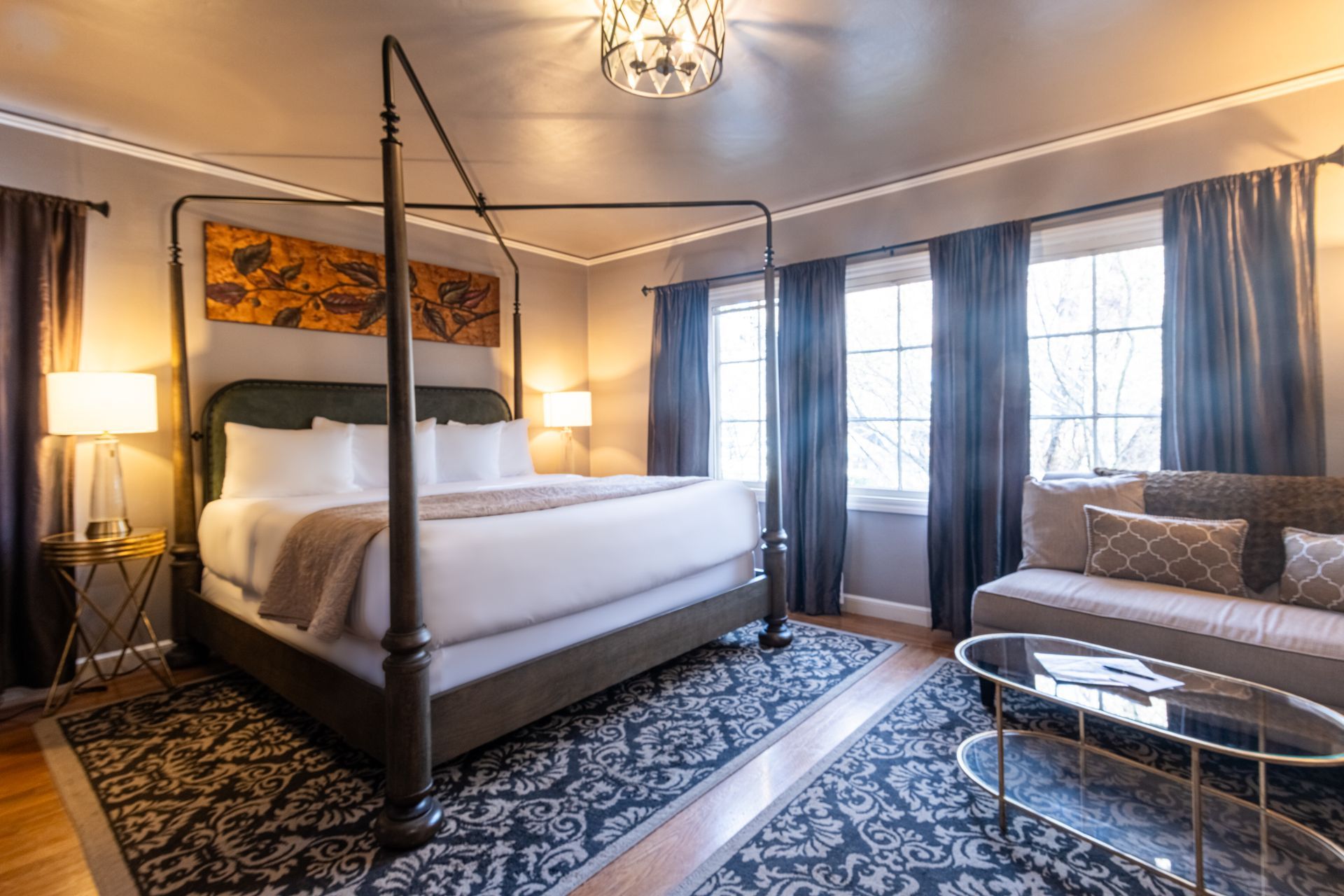 A bedroom with a four poster bed and a couch.