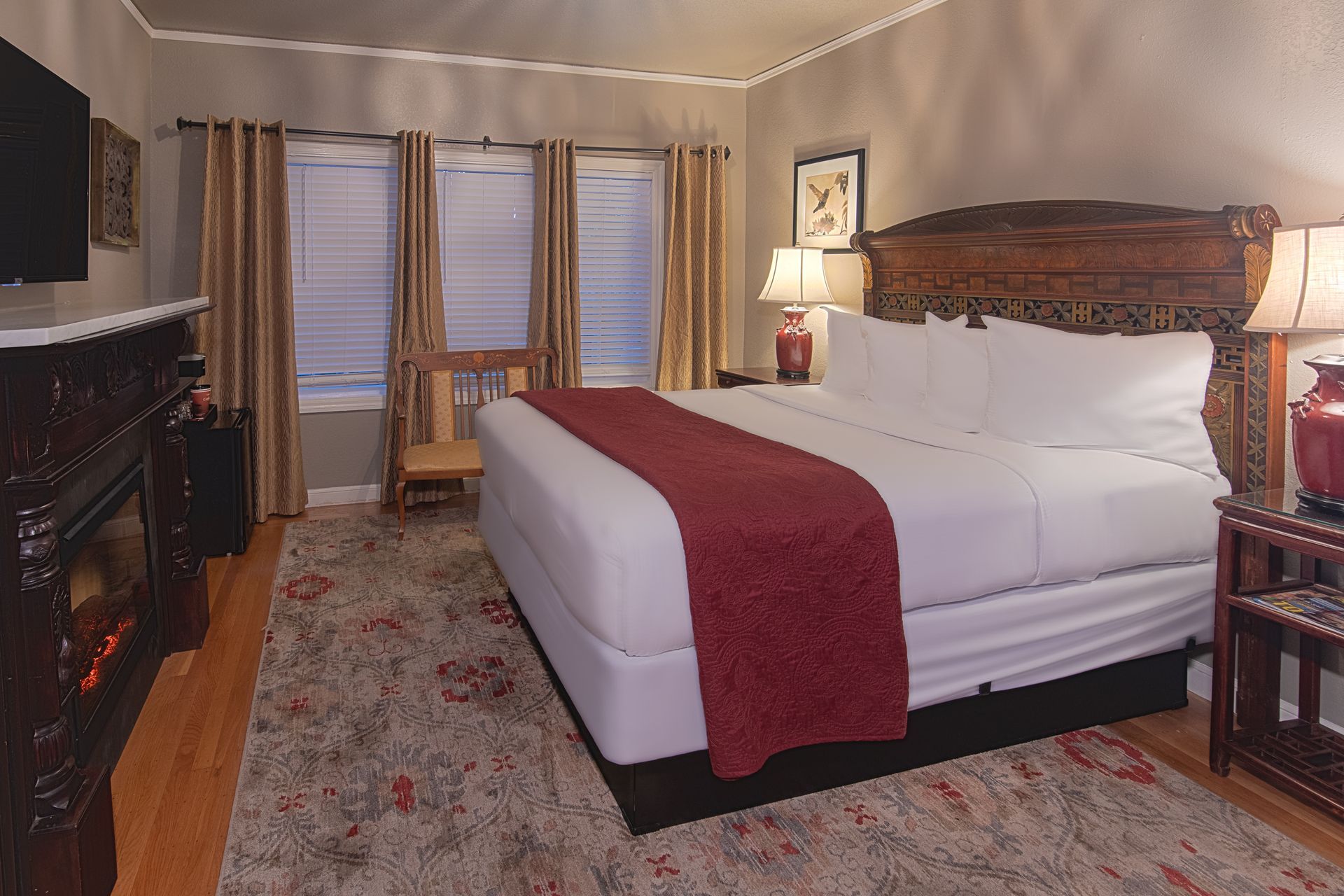 A hotel room with a king size bed and a fireplace.
