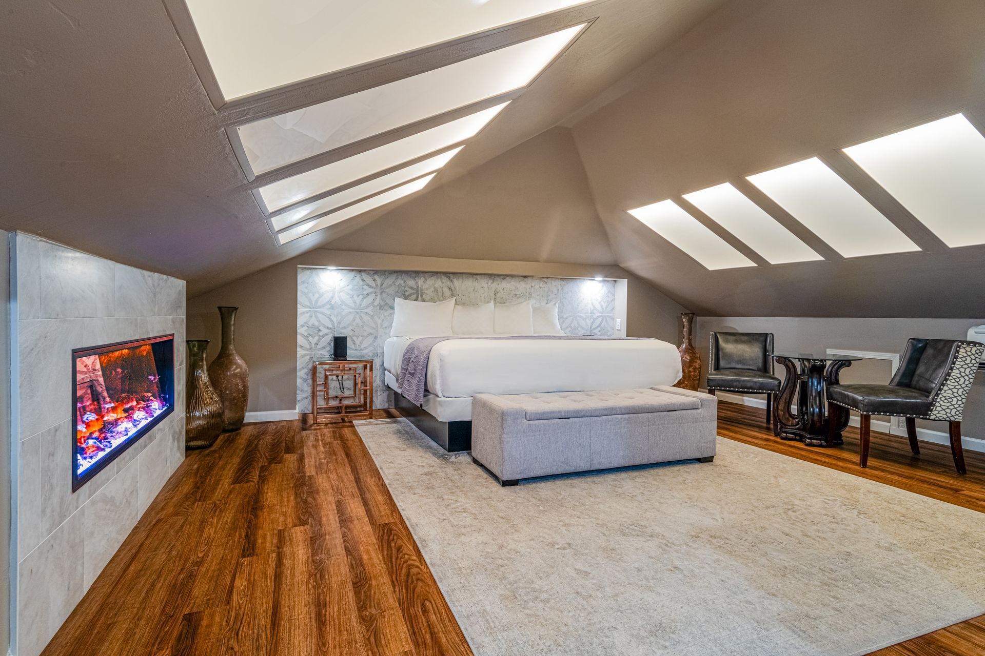 A bedroom with a king size bed and a fireplace.