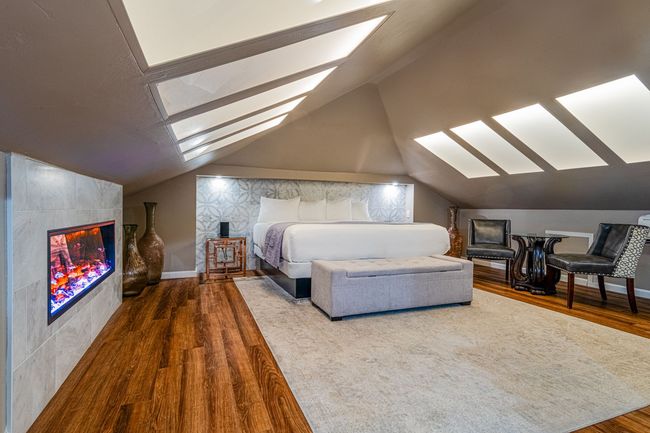 A bedroom with a king size bed and a fireplace.