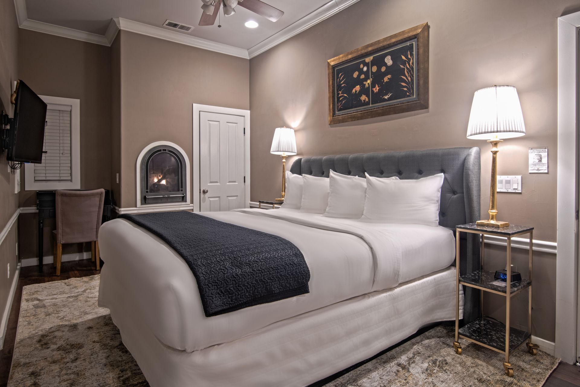 A hotel room with a king size bed and a fireplace.