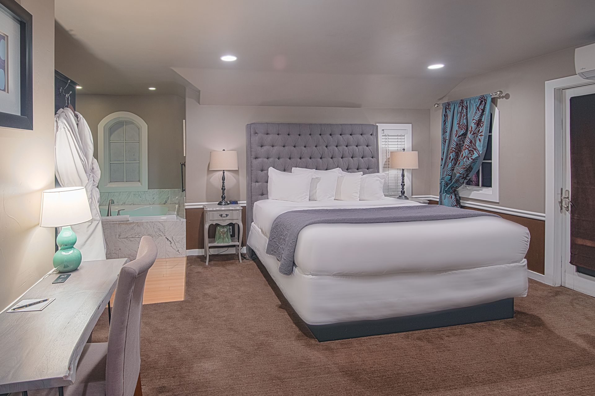A hotel room with a king size bed and a jacuzzi tub.