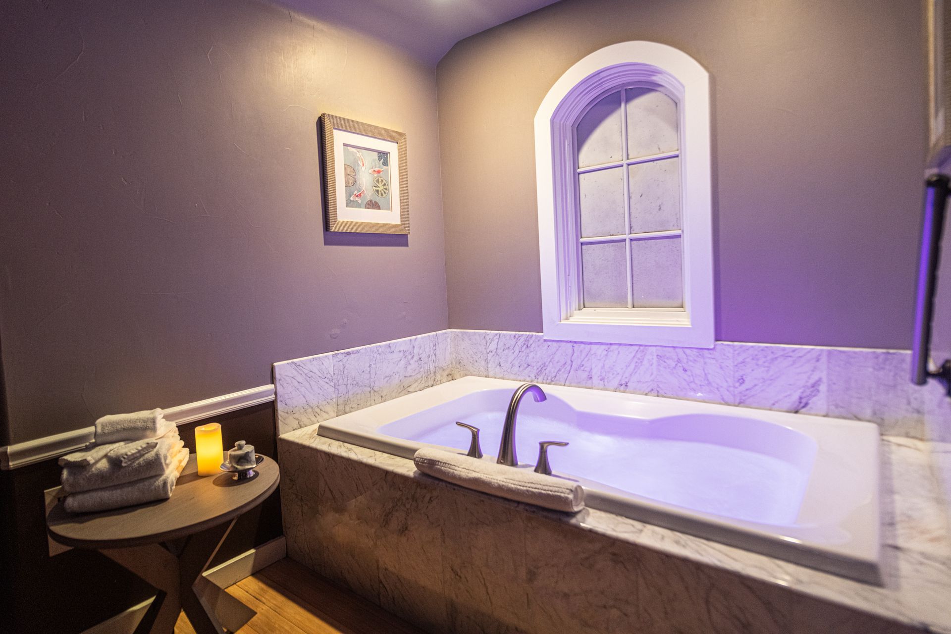 A bathroom with a jacuzzi tub and a window.