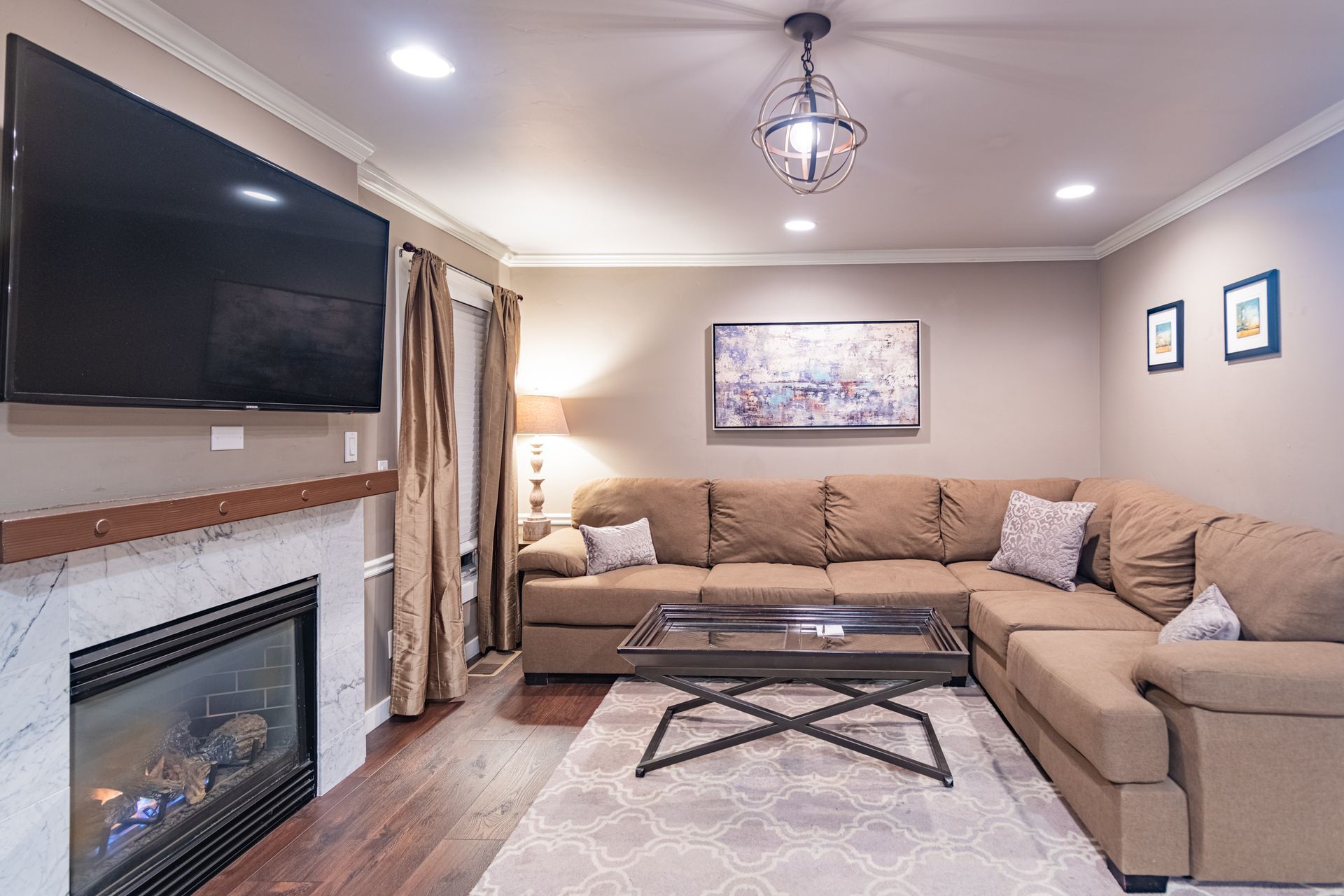 A living room with a couch , fireplace , and flat screen tv.