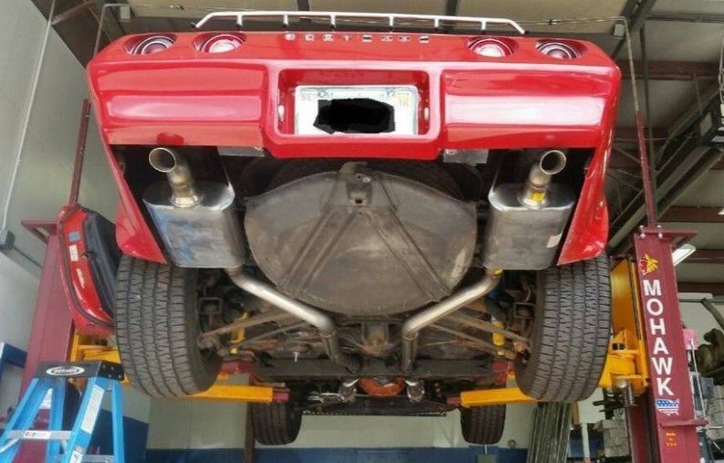 Red sports car with new muffler system installation at Lou’s Custom Exhaust in Worcester, MA