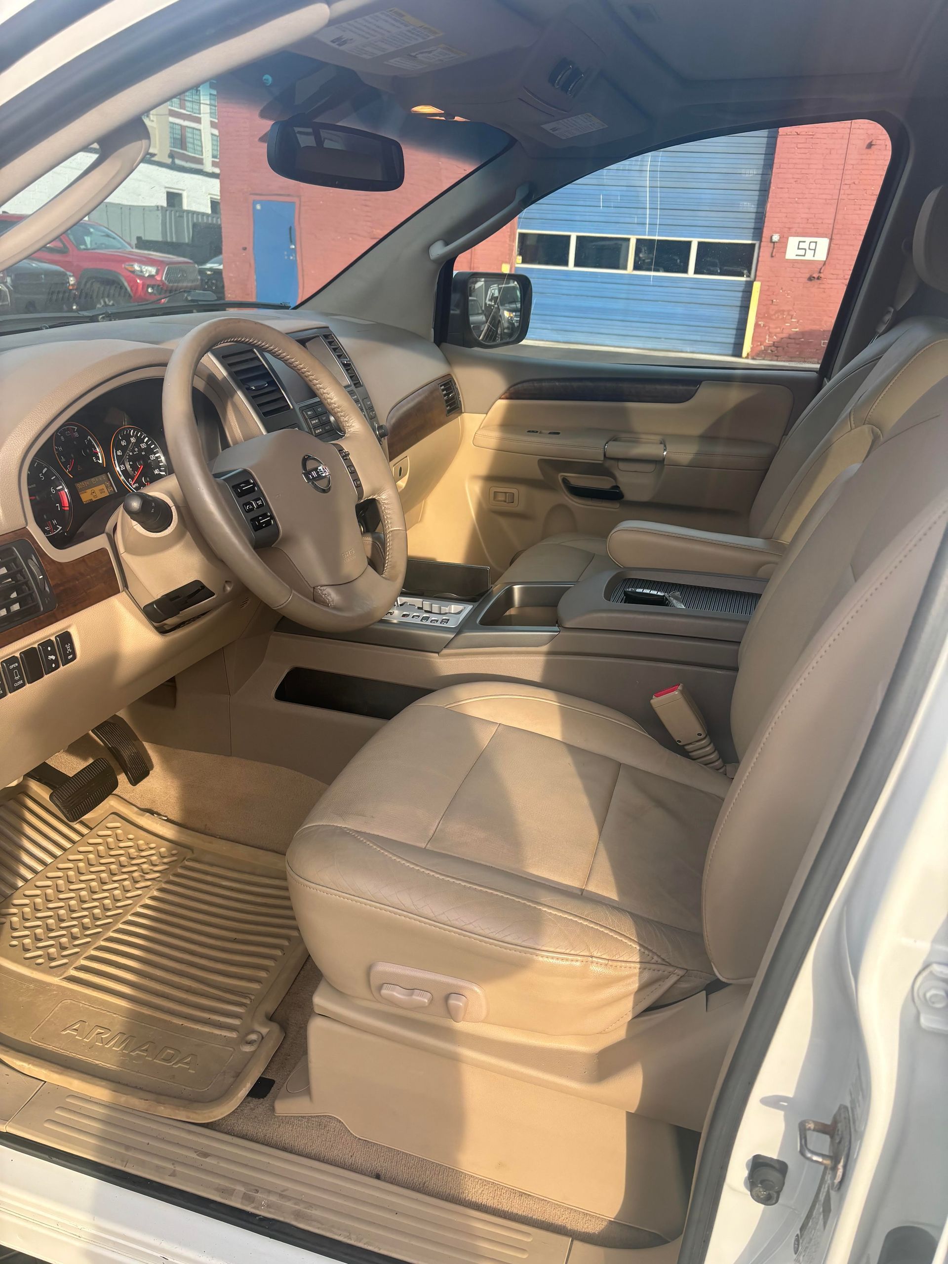 Front interior and steering wheel of Nissan Armada SUV at Lou’s Custom Exhaust Worcester MA