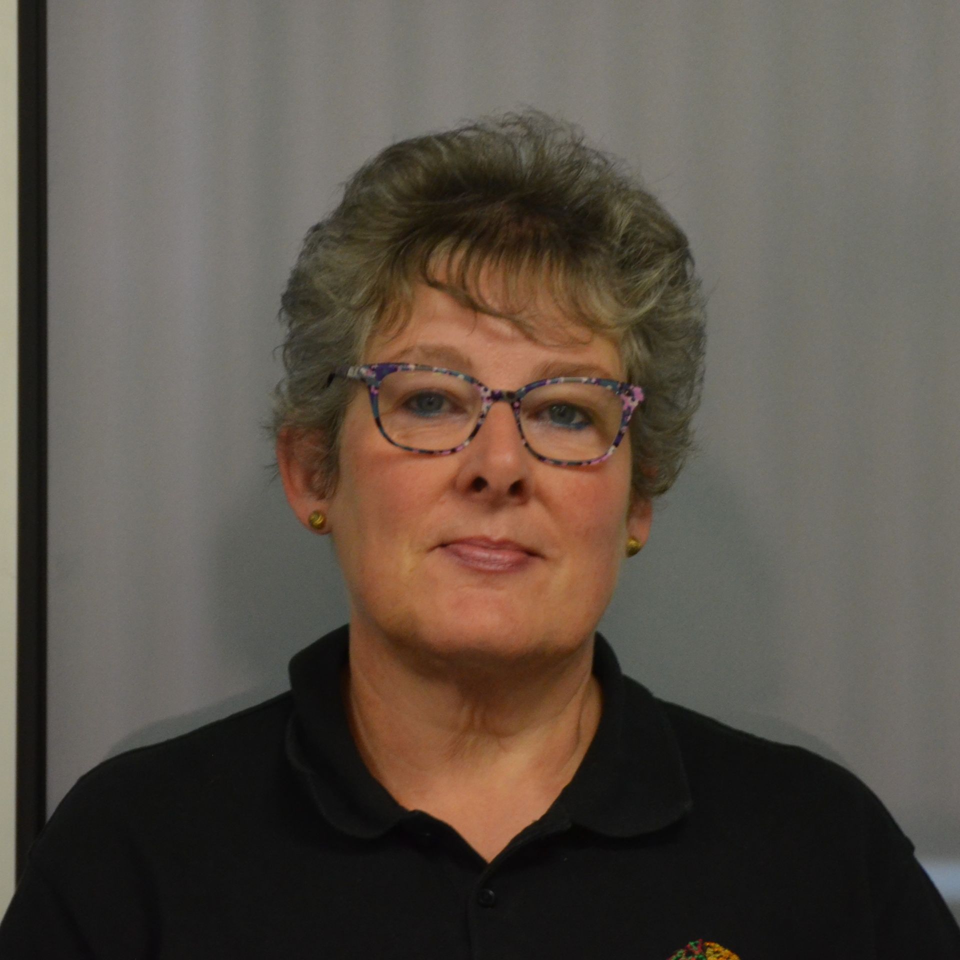 A woman wearing glasses and a louis vuitton sweater
