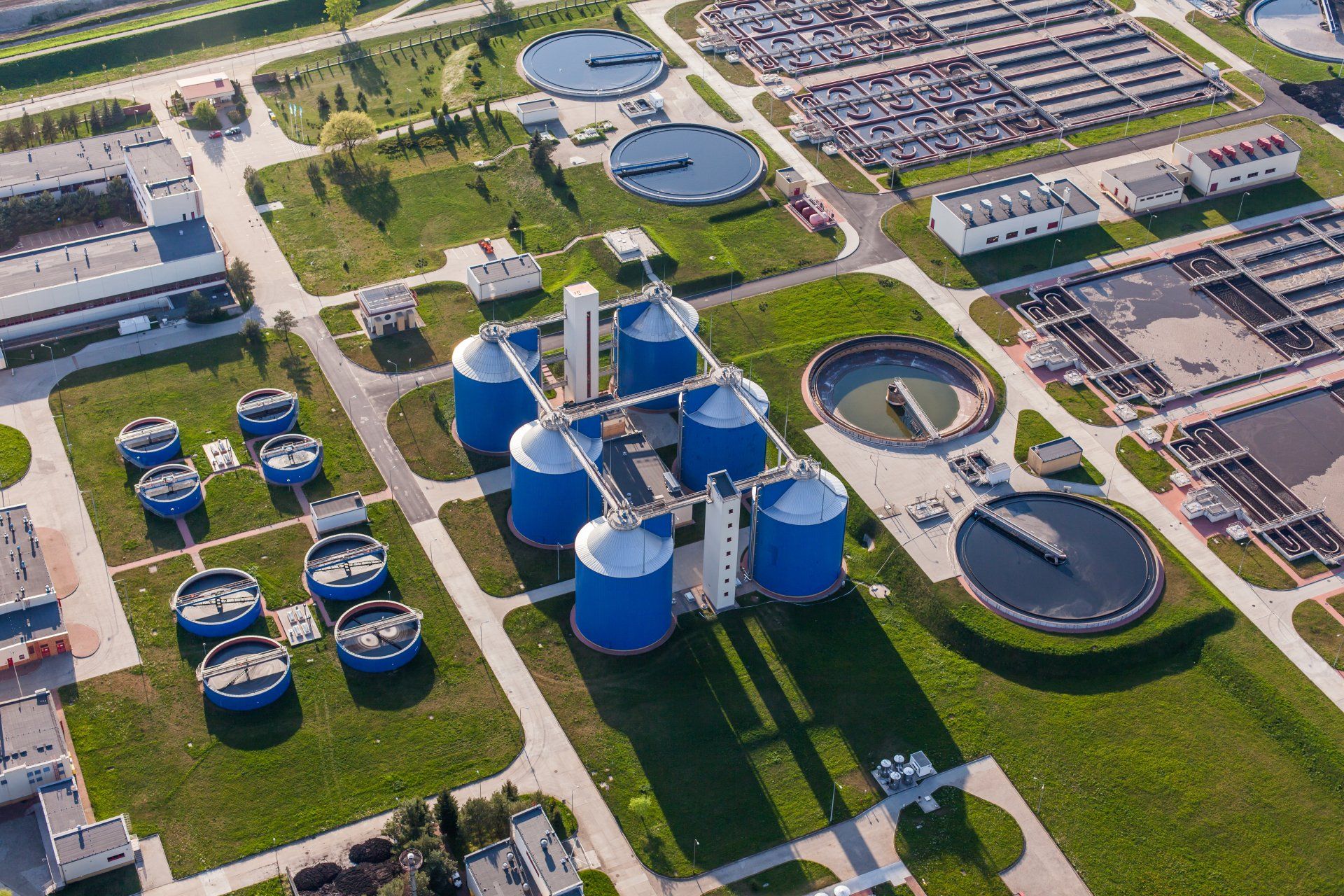 An aerial view of a water treatment plant with blue tanks.