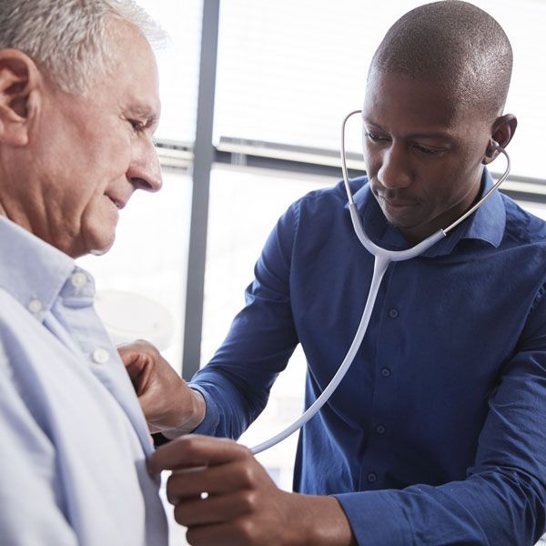 Doctor using a stethoscope to examine a patient in a bright clinic