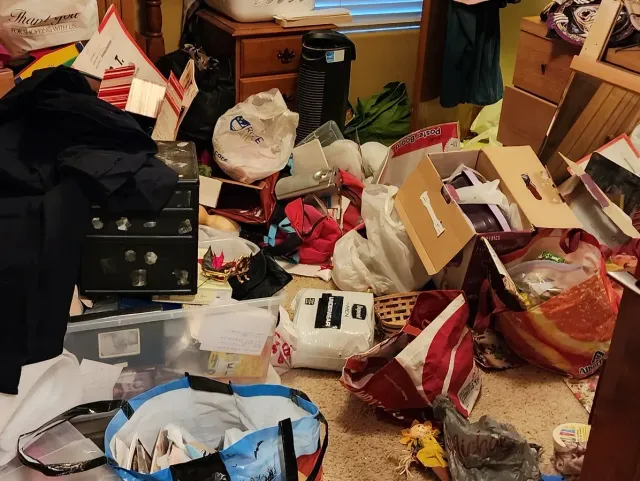 A messy room with a lot of boxes and bags on the floor in bakersfield
