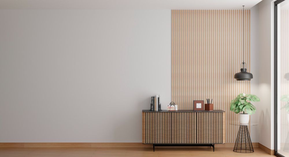 A living room with a wooden dresser and a potted plant.