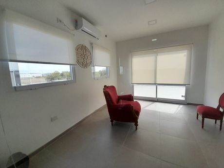 Una habitación luminosa y minimalista con suelo de baldosas, dos sillones rojos