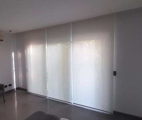 Vista de una habitación moderna con estores enrollables blancos