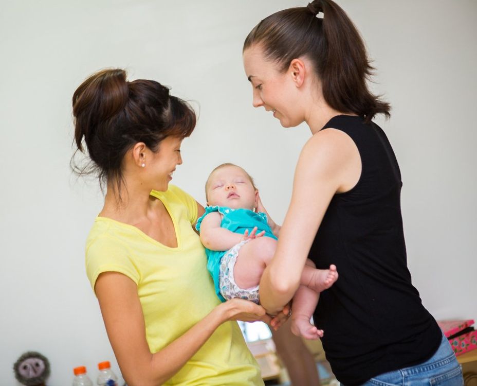 Two Women Carrying a Baby — Darwin, NT — Territory Child Care Group