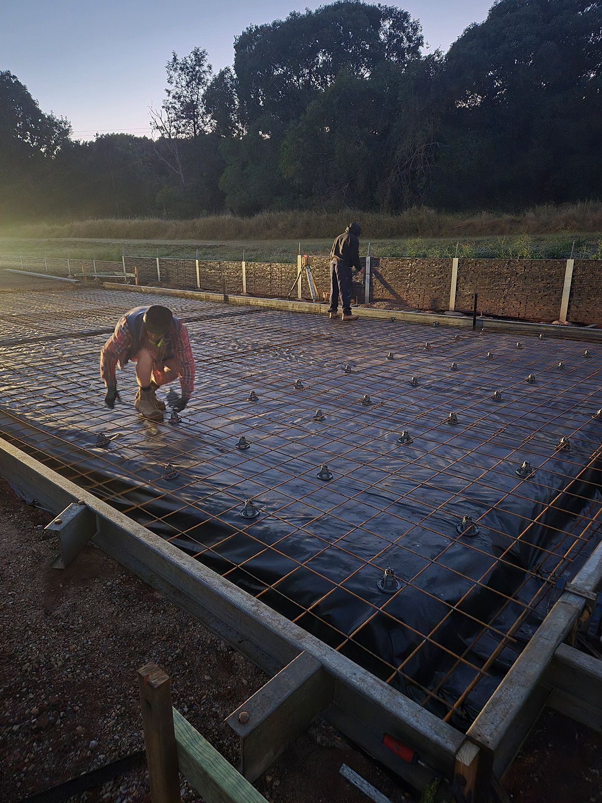 Two Workers on a Rebar Slab at Dusk — TP Concreting In Warilla, NSW