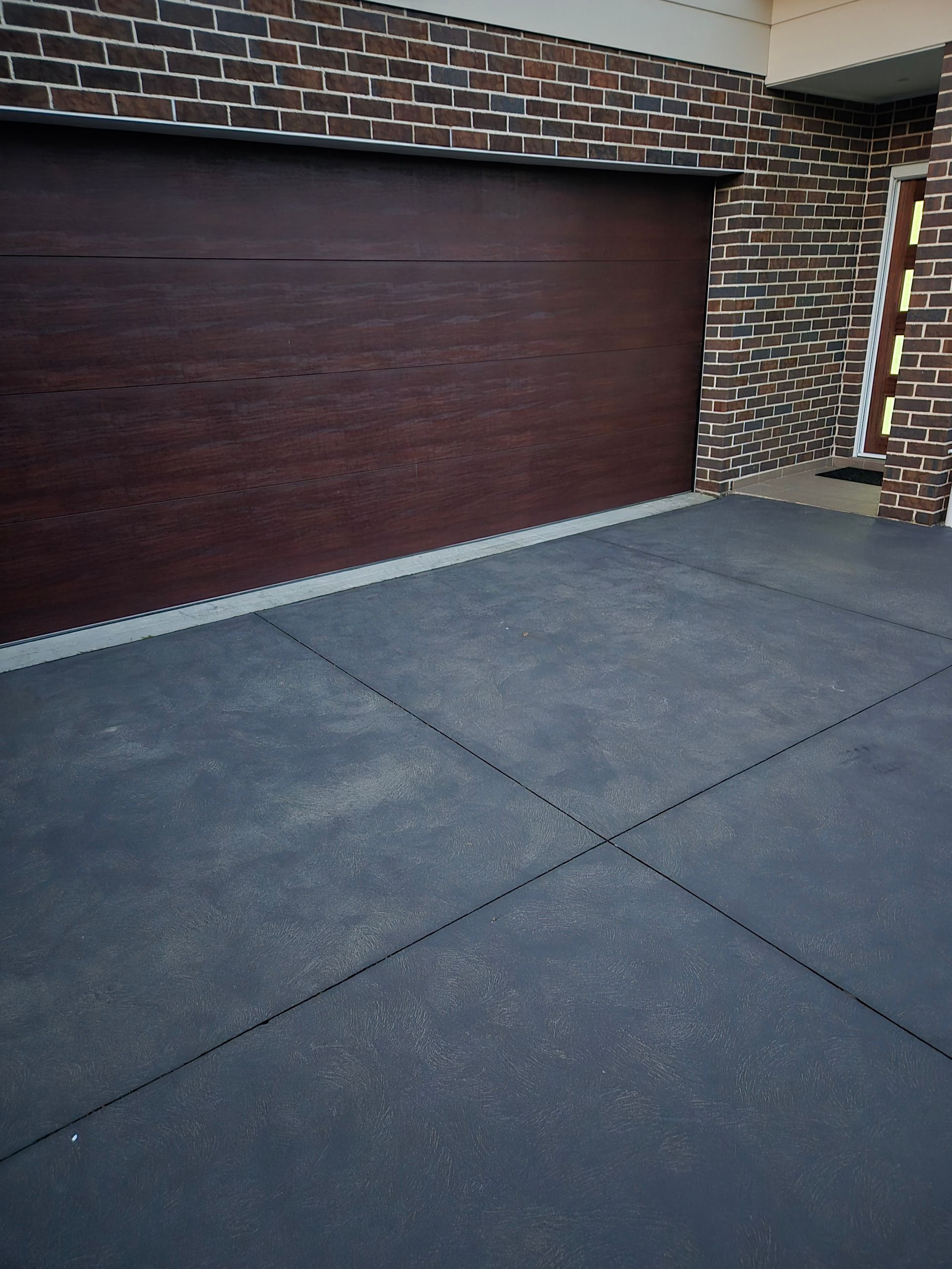 Closed Dark Wood Garage Door on a Brick House — TP Concreting In Kingaroy, QLD