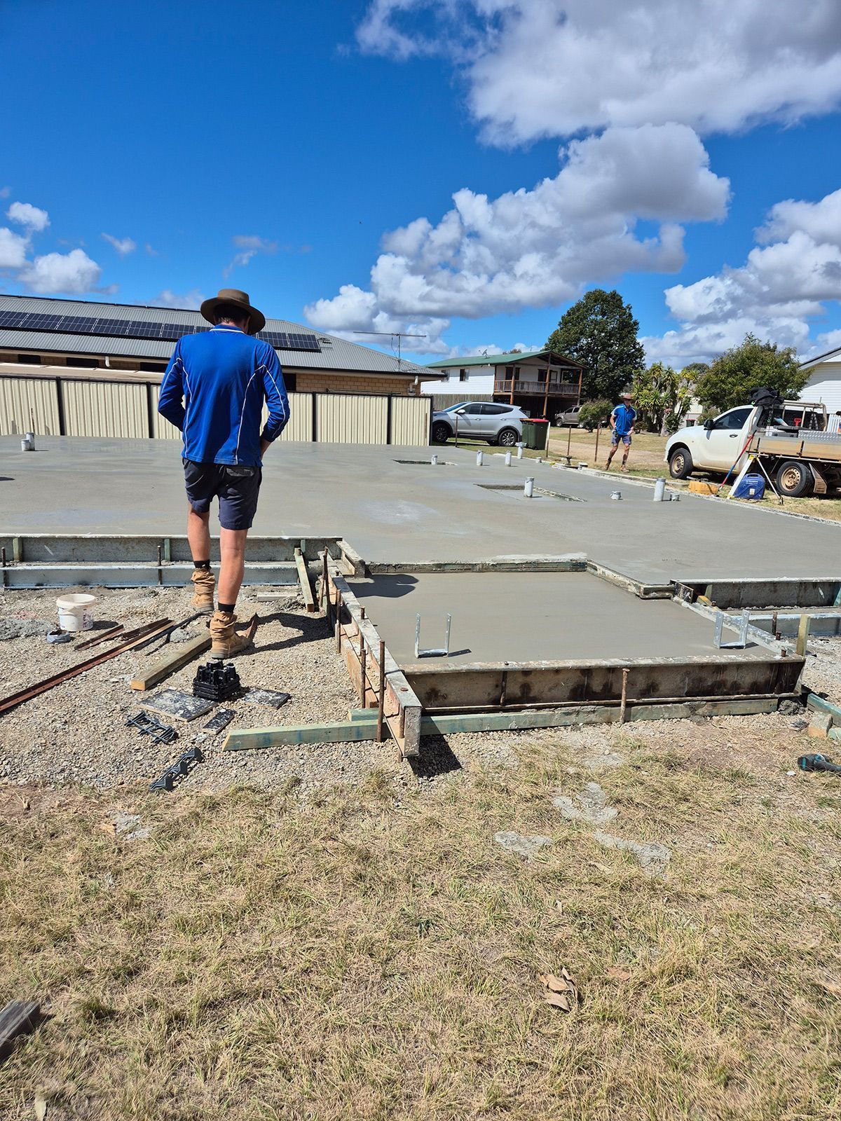 Workers Laying a Concrete Slab Foundation on a Sunny Construction Site — TP Concreting In Warilla, NSW