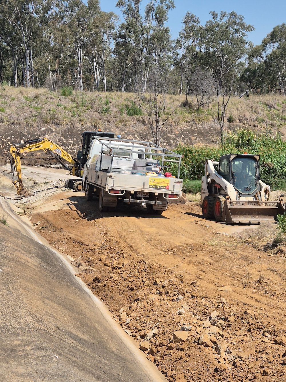 Excavator and Skid Steer Working on a Dirt Road — TP Concreting In Illawarra, NSW