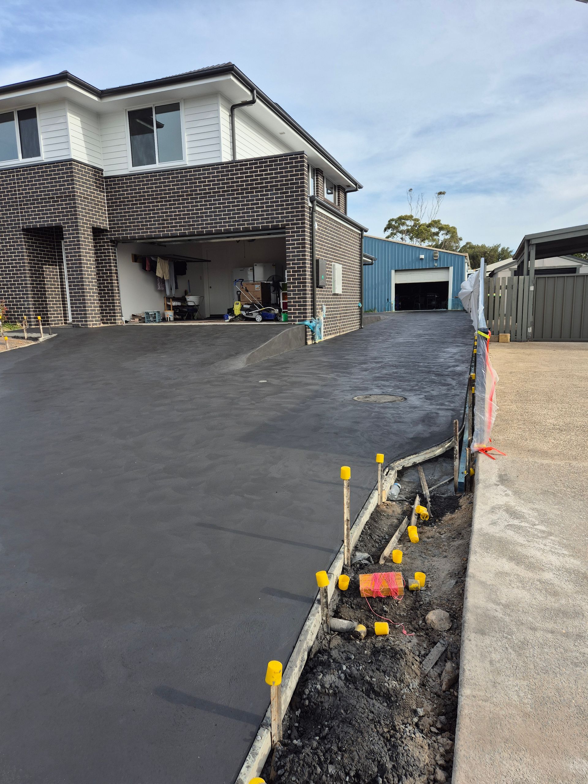 New Black Asphalt Driveway Beside a Townhouse — TP Concreting In Illawarra, NSW