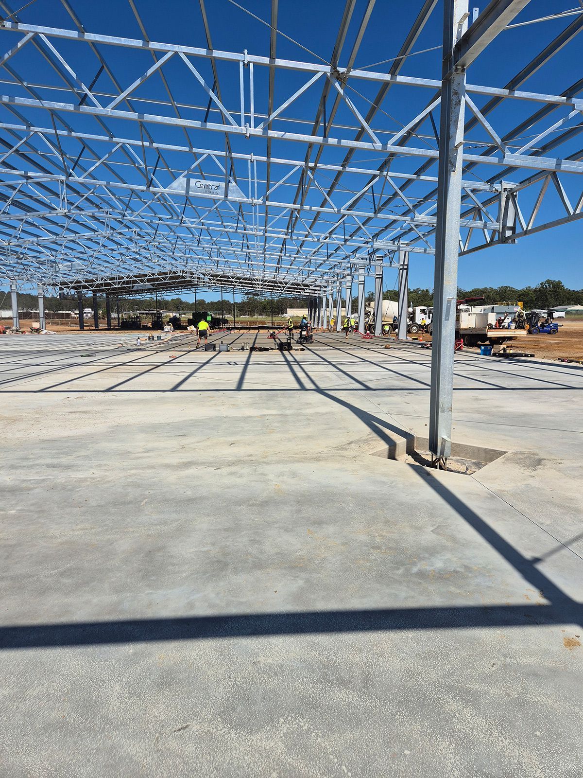 Steel-frame Building Under Construction on a Concrete Slab in Bright Daylight — TP Concreting In Warilla, NSW