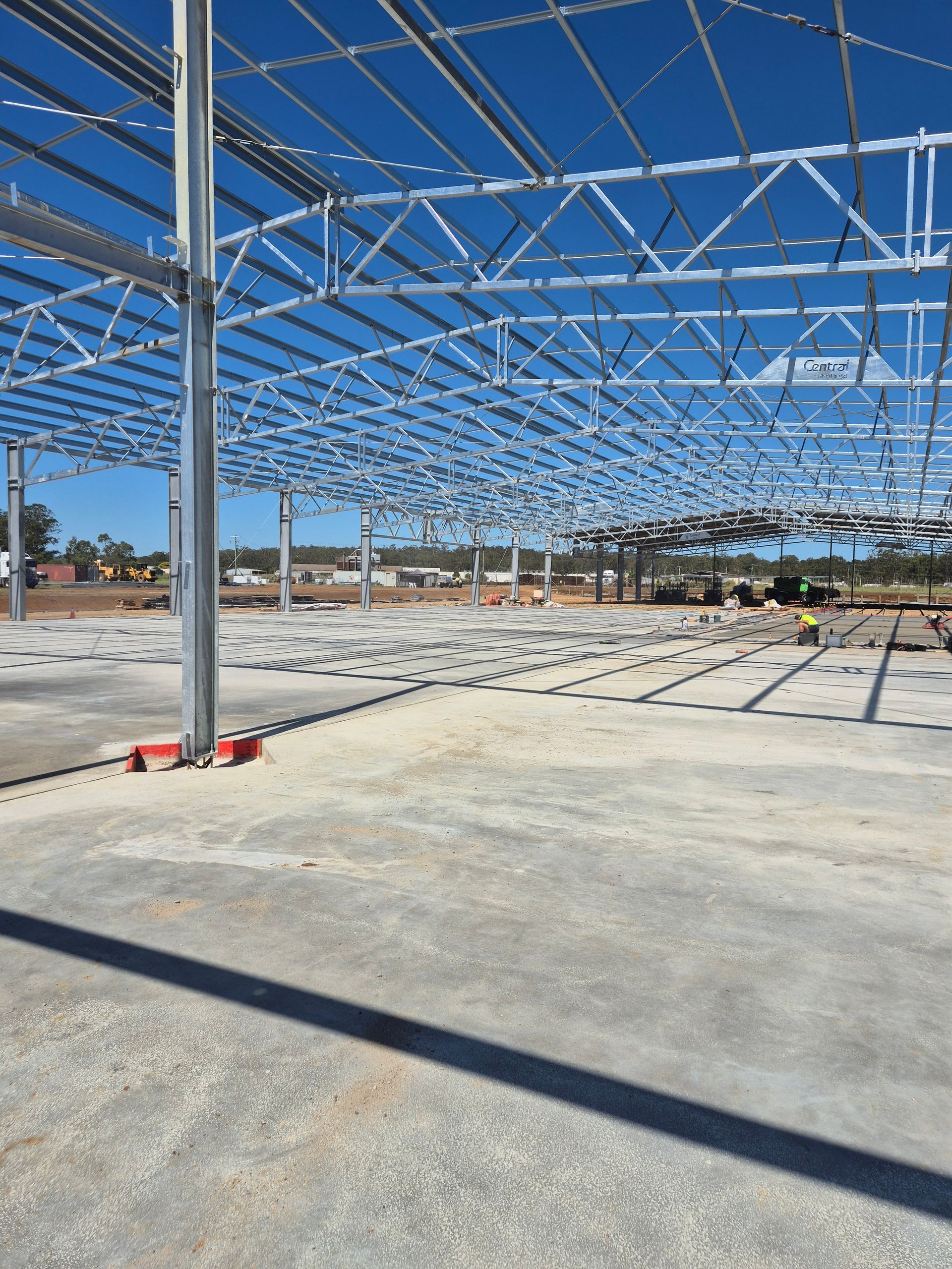 Steel Frame Building Under Construction on a Concrete Slab— TP Concreting In Shellharbour, NSW