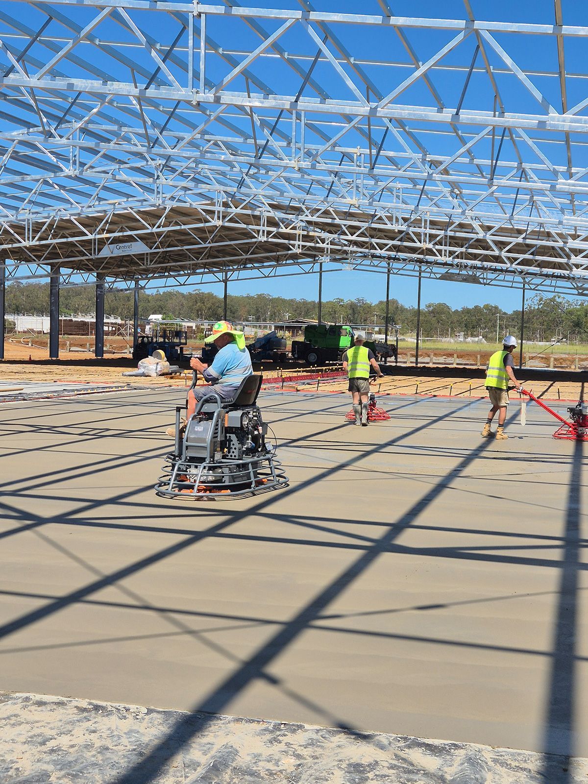 Workers in High-visibility Vests Smoothing a Concrete Slab — TP Concreting In Warilla, NSW