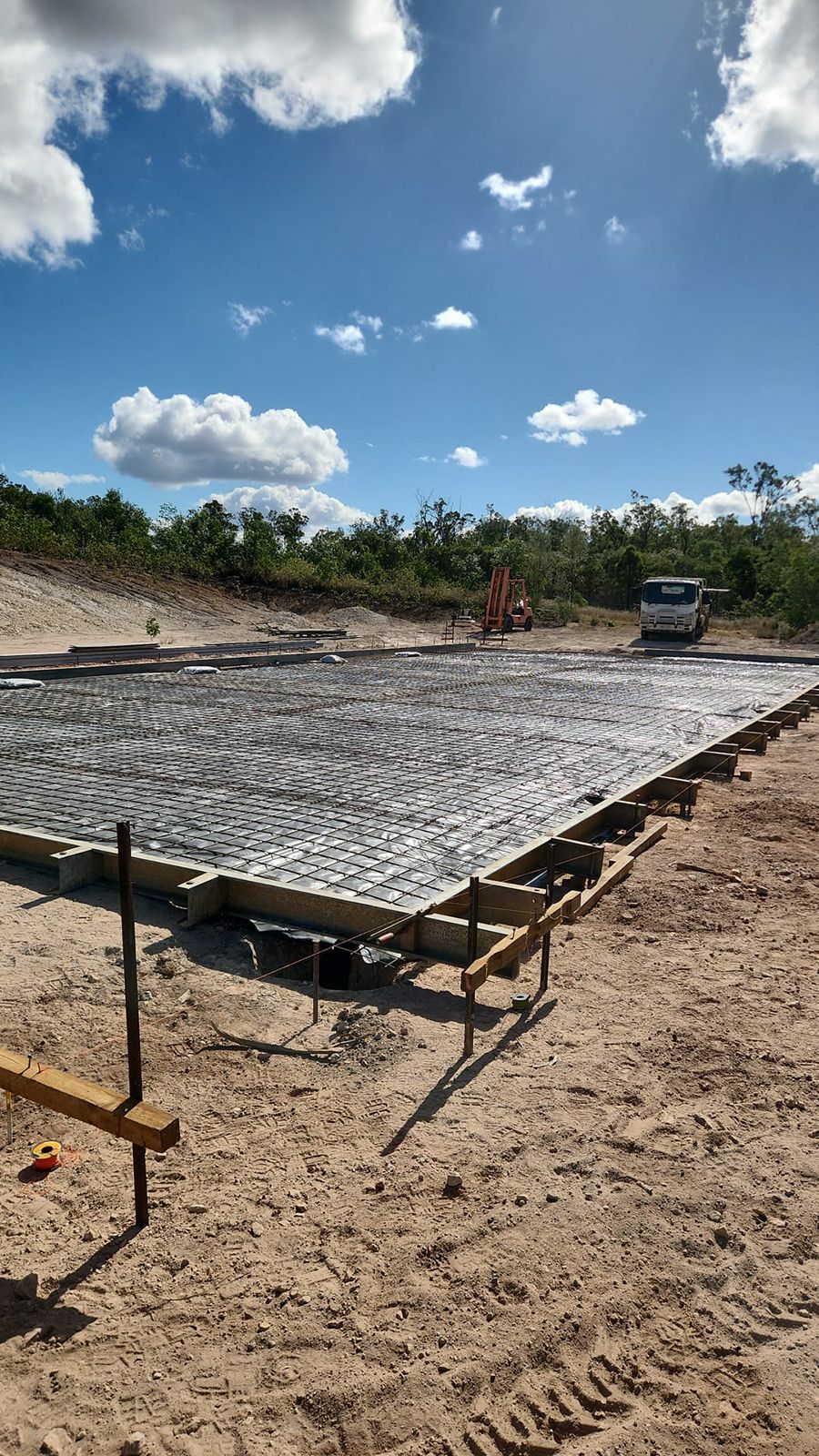 Construction Site With Large Concrete Slab Foundation Under a Blue Sky — TP Concreting In Warilla, NSW