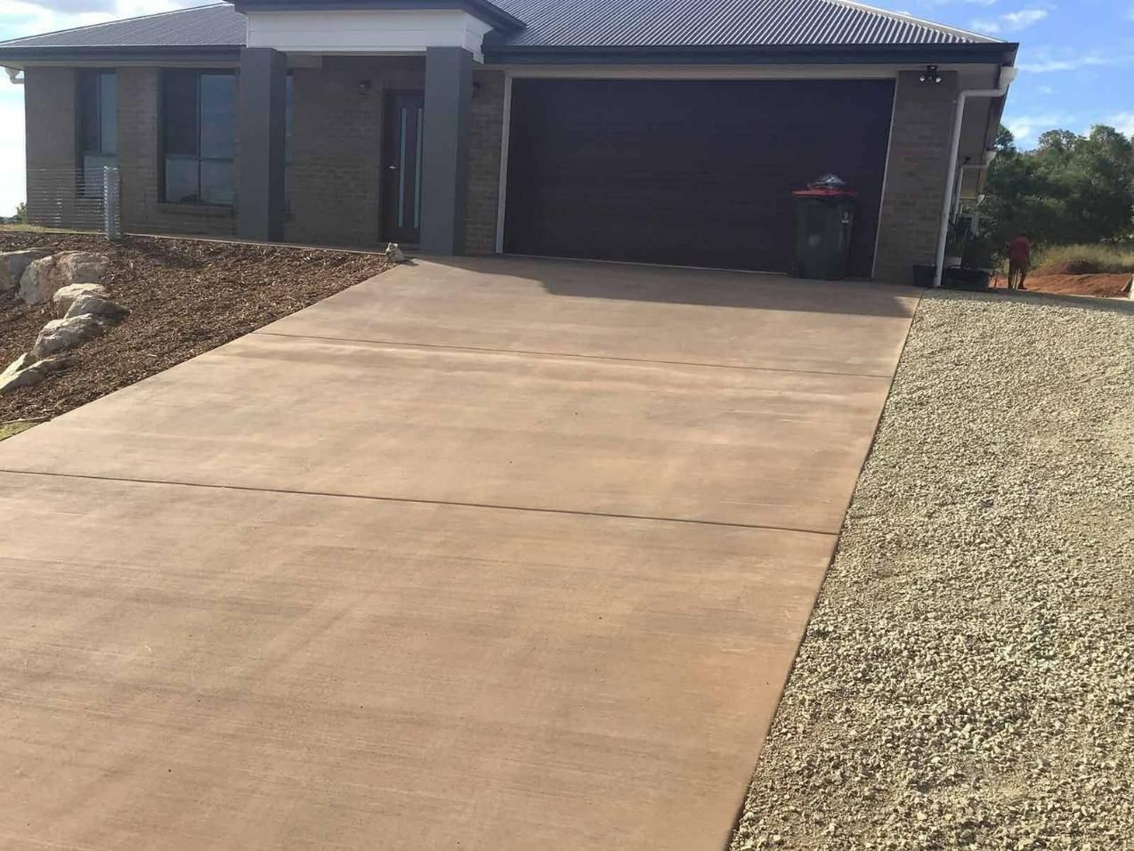 A Driveway Leading To A House With A Garage Door — TP Concreting In Warilla, NSW