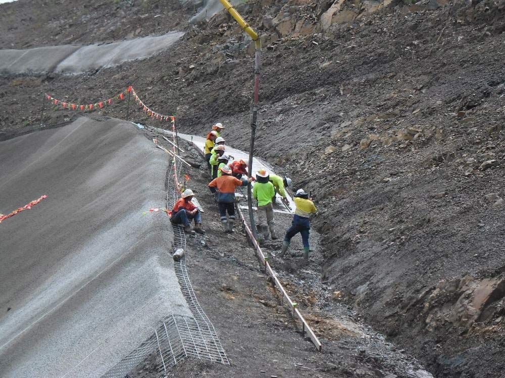 A Group Of Construction Workers Are Working On A Hillside — TP Concreting In Warilla, NSW