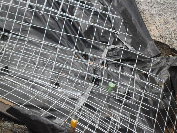 A Piece Of Wire Mesh Is Laying On A Black Tarp — TP Concreting In Warilla, NSW