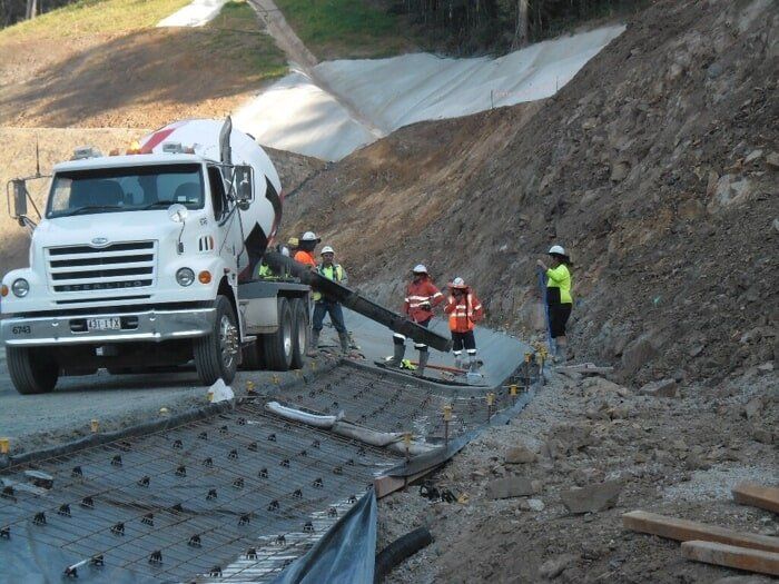 A White Truck Is Driving Down A Dirt Road — TP Concreting In Nanango, QLD