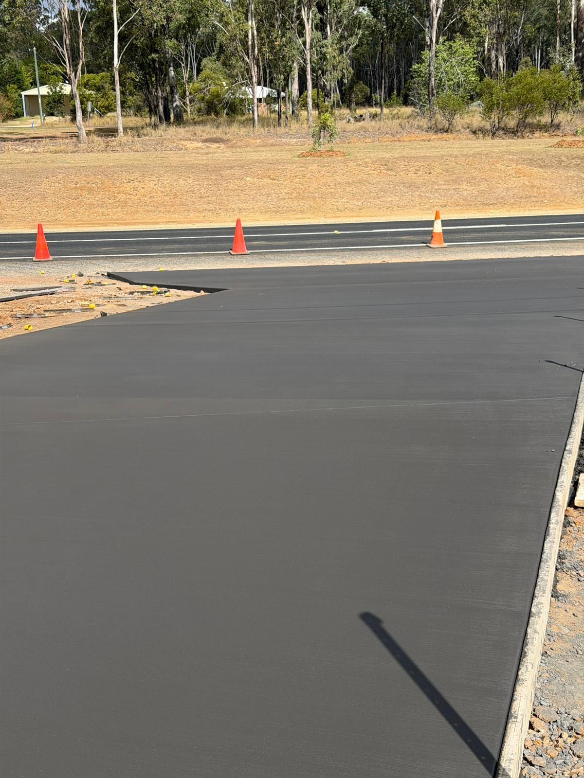 Freshly Paved Road With Orange Traffic Cones— TP Concreting In Kingaroy, QLD