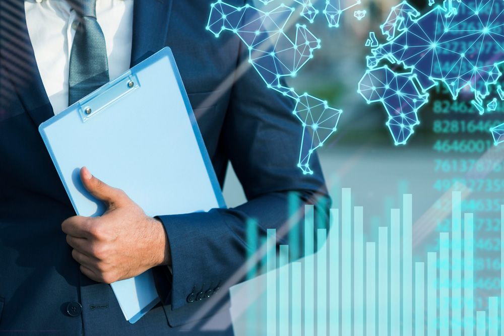 A man in a suit and tie is holding a clipboard and giving a thumbs up.